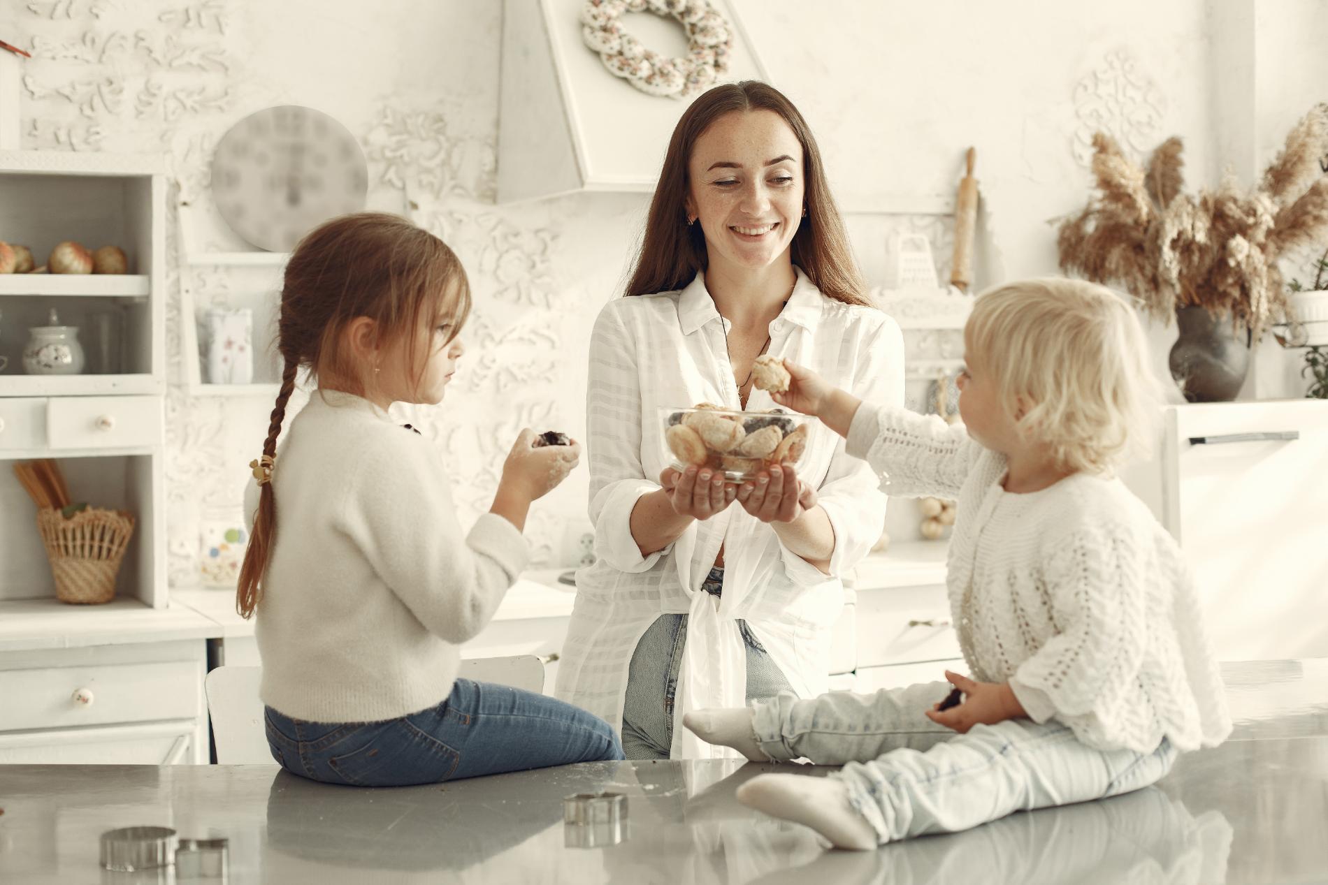 Three generations of a family talking around a light kitchen island
