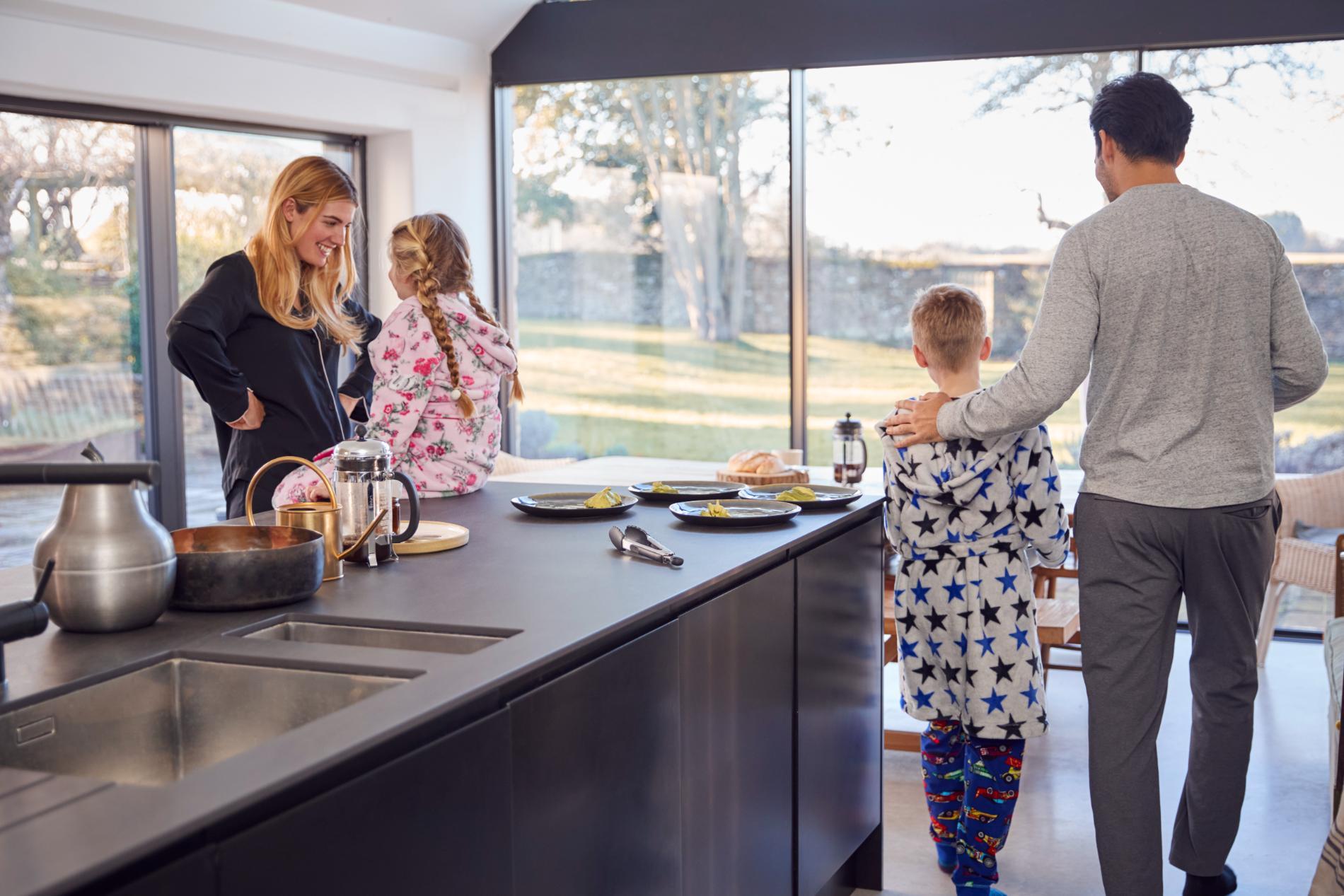 Family gathered beside a dark kitchen island with an undermount sink